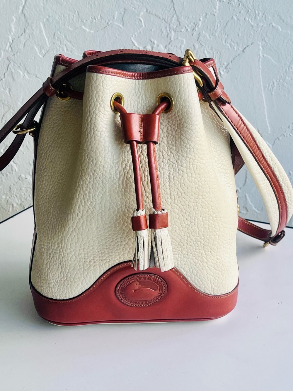 VINTAGE DOONEY AND BOURKE CREAM AND TAN LEATHER SHOULDER BUCKET